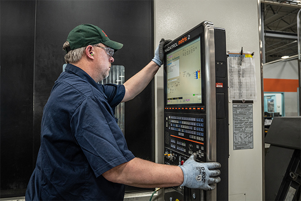 An L&M Radiator employee uses a machine’s program to ensure strict adherence to predetermined, uniform measurements.